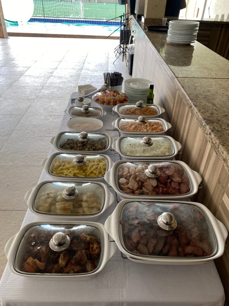Travessas do buffet com arroz, feijão e carnes
